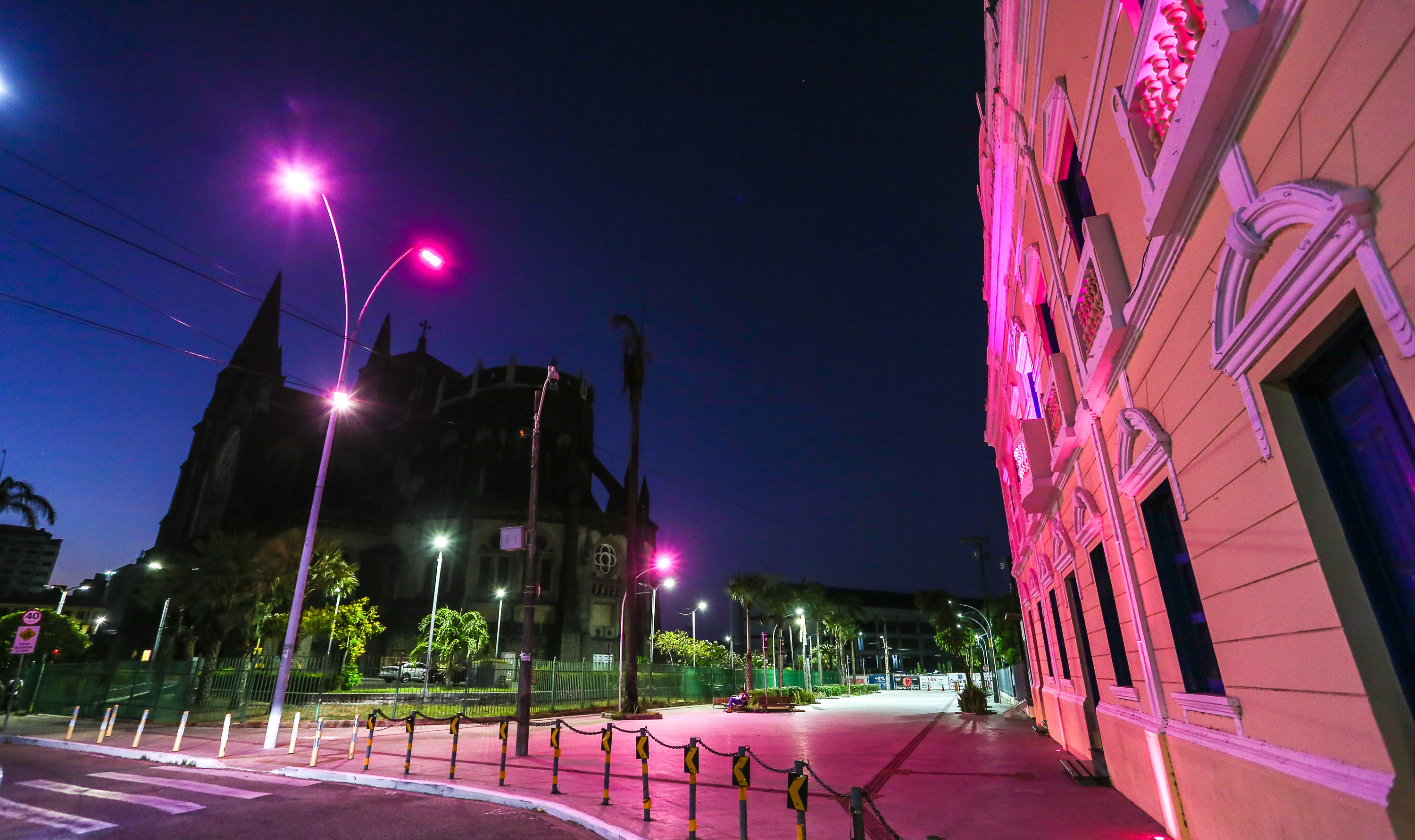 a foto mostra o paço municipal e a catedral de fortaleza iluminados por uma luz rosa